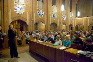 Todd Wilson speaking with the audience before accompanying the Phantom of the Opera on the church's pipe organ.